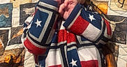 Waylon is registered to the contest to win money with this photo: baby, infant, child, portrait, lying_down, smiling, face, hands, fingers, blanket, quilt, cowboy_theme, horses, western, red_white_blue, striped_clothing, star_pattern, indoors, cozy, photograph