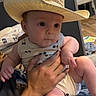 baby, child, cowboy_hat, straw_hat, infant, portrait, indoors, being_held, smiling, wide_eyed, clothing, bib, diaper, adult_hand, family, high_chair, baby_supplies, home, cute, photography