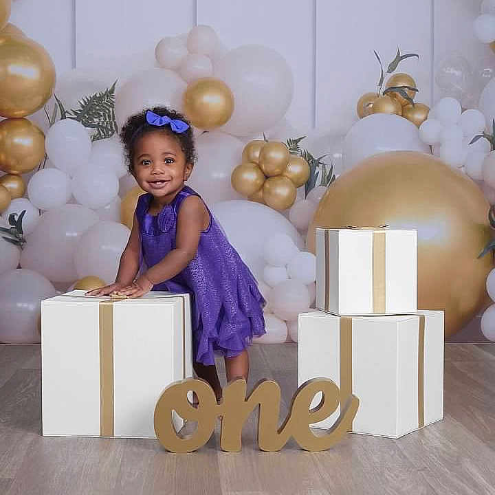 Kataleya is registered to the contest to win money with this photo: box, child, clothing, face, female, festival, girl, hair, head, number, openingpresent, person, sitting, sleeve, symbol, text