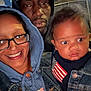 woman, man, baby, glasses, hoodie, denim_jacket, cap, smile, serious_expression, outdoor, night, family, portrait, face, people, child, casual_clothing, flag_patch, closeup, group
