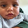 Bleu is registered to the contest to win money with this photo: baby, close_up, face, child, person, skin, eyes, clothing, infant, cute, portrait, expression, human, young, chubby_cheeks, casual, indoor, soft_lighting, holding, resting