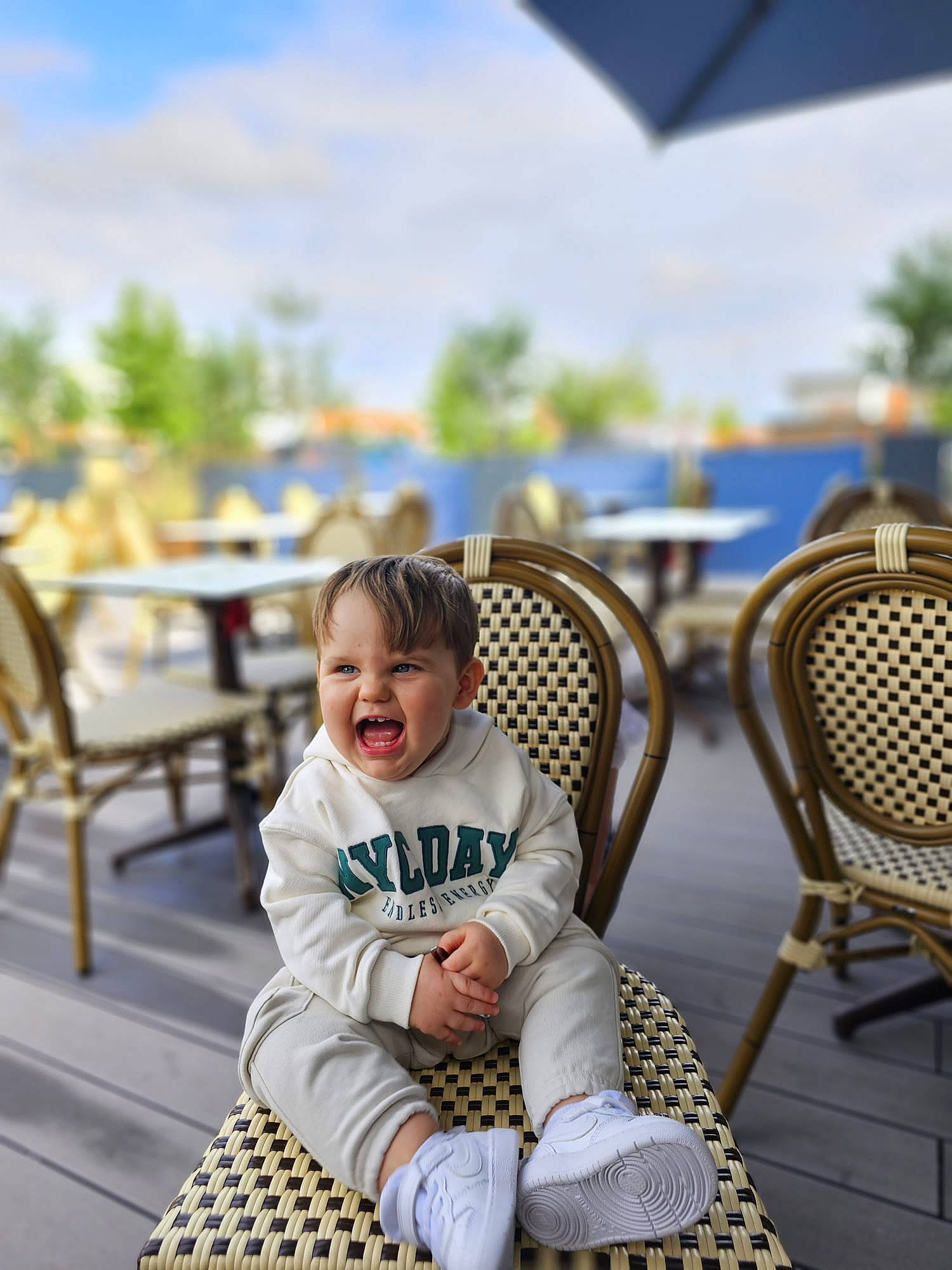 Ilan a rejoint le concours — aidez-le/la à gagner de superbes lots ! chair, child, event, fun, furniture, grass, happy, leisure, outdoor_furniture, outdoor_table, person, recreation, sitting, sky, smile, summer, table, toddler, tourism, tree