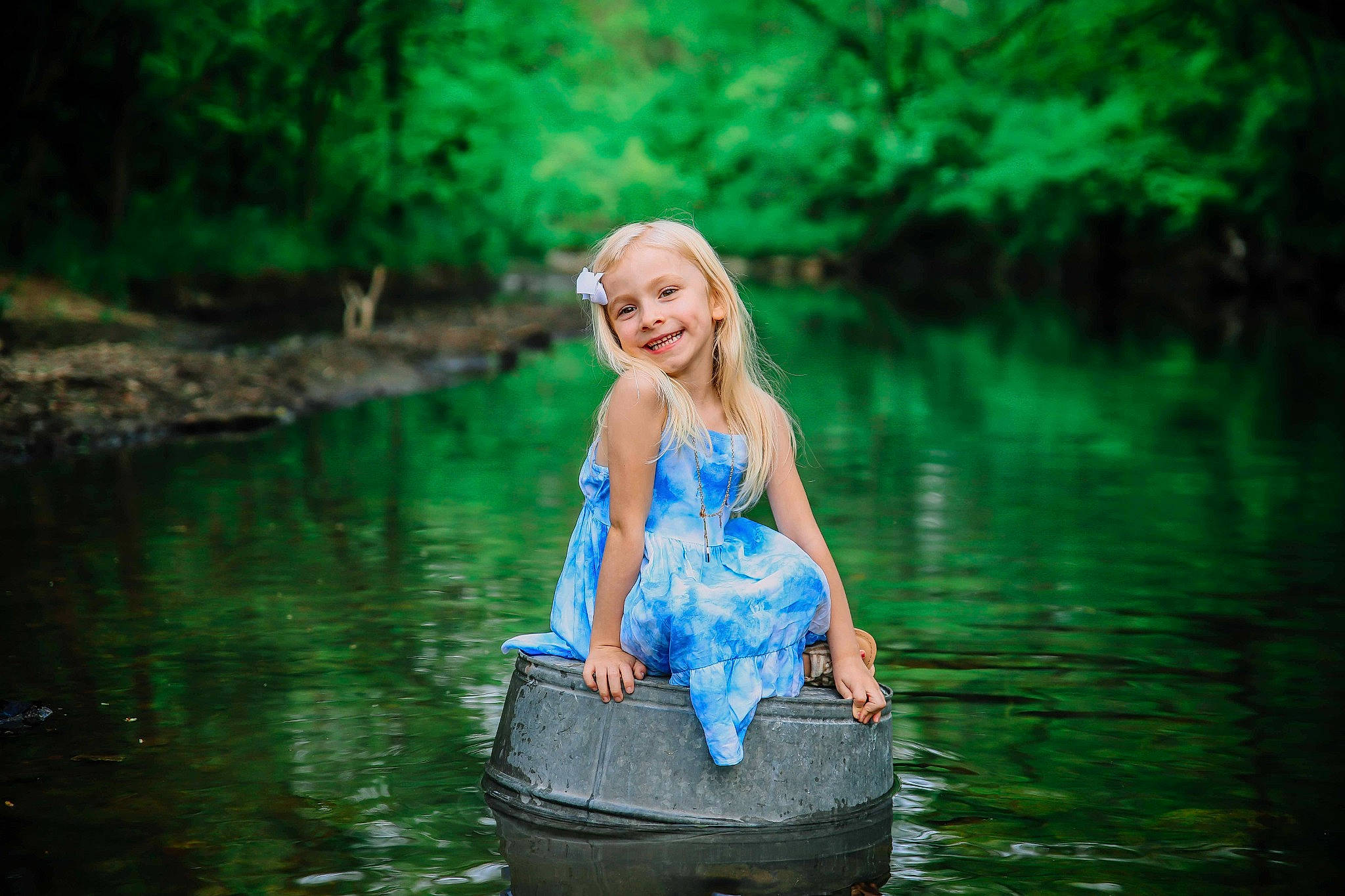 Mary is registered to the contest to win money with this photo: bank, dress, flash_photography, forest, fun, grass, green, happy, joy, lake, landscape, leisure, long_hair, natural_environment, natural_landscape, people_in_nature, person, plant, recreation, smile