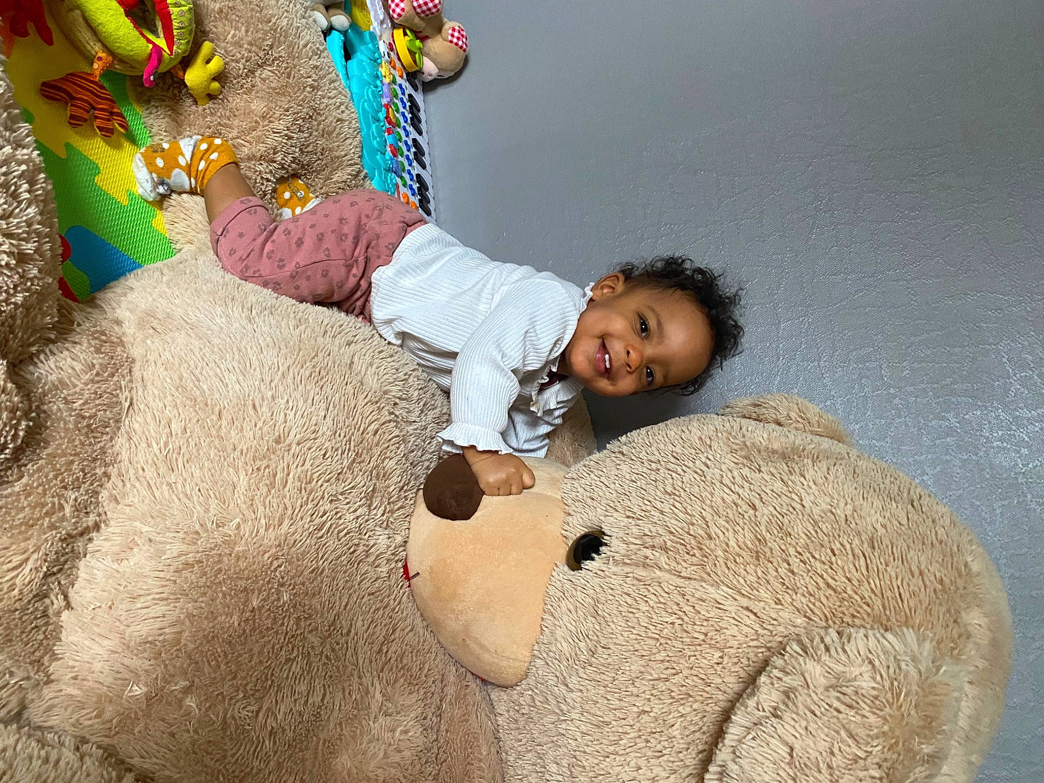 Naëva a rejoint le concours — aidez-le/la à gagner de superbes lots ! adaptation, child, comfort, flooring, fun, fur, hand, happy, joy, leisure, linens, pattern, people_in_nature, person, room, sitting, smile, stuffed_toy, teddy_bear, textile