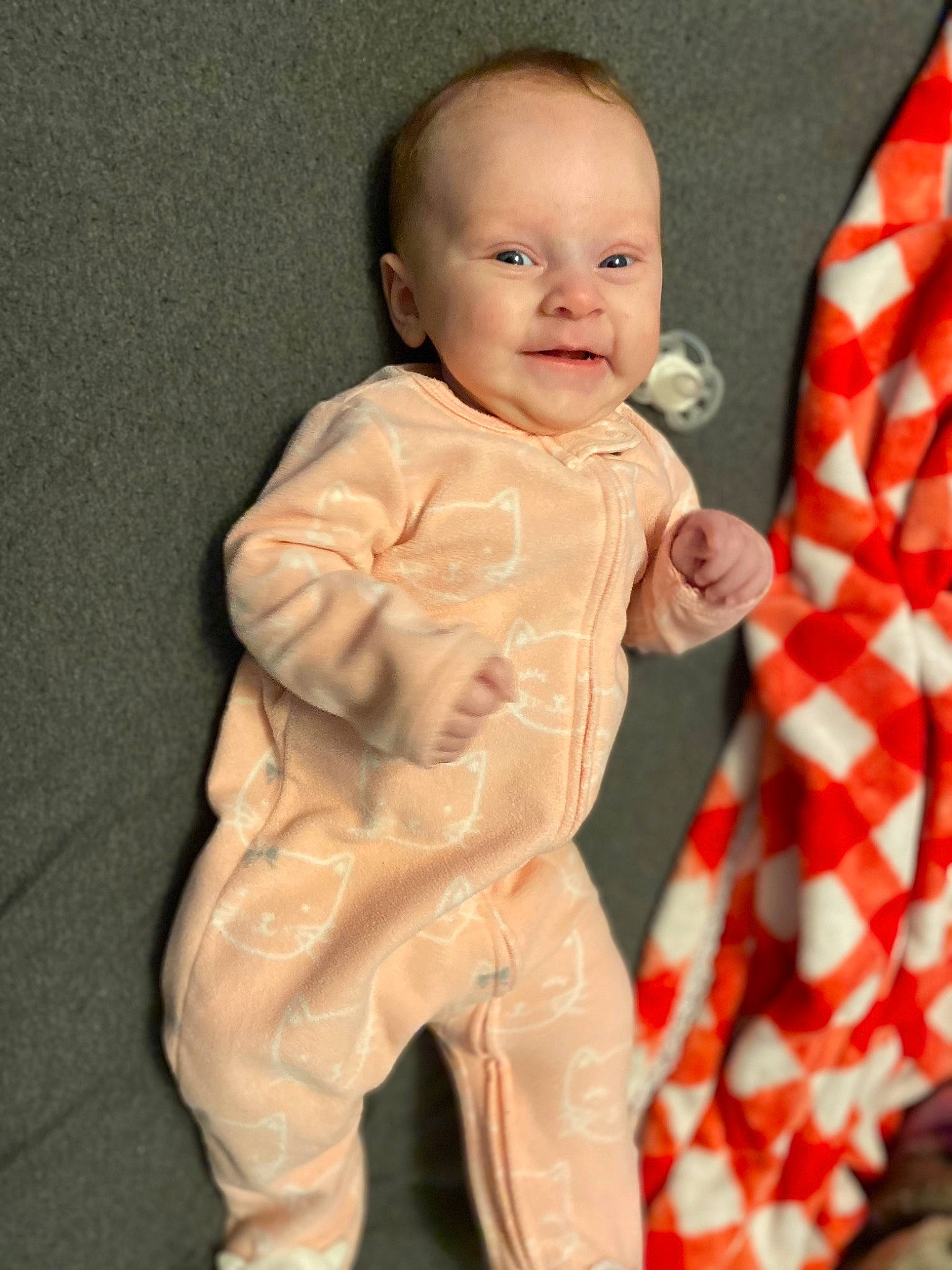 Juniper joined the competition — help win amazing prizes! baby, baby_toddler_clothing, cheek, child, event, finger, gesture, happy, human_body, linens, pattern, peach, person, plaid, sitting, skin, sleeve, smile, thumb, toddler