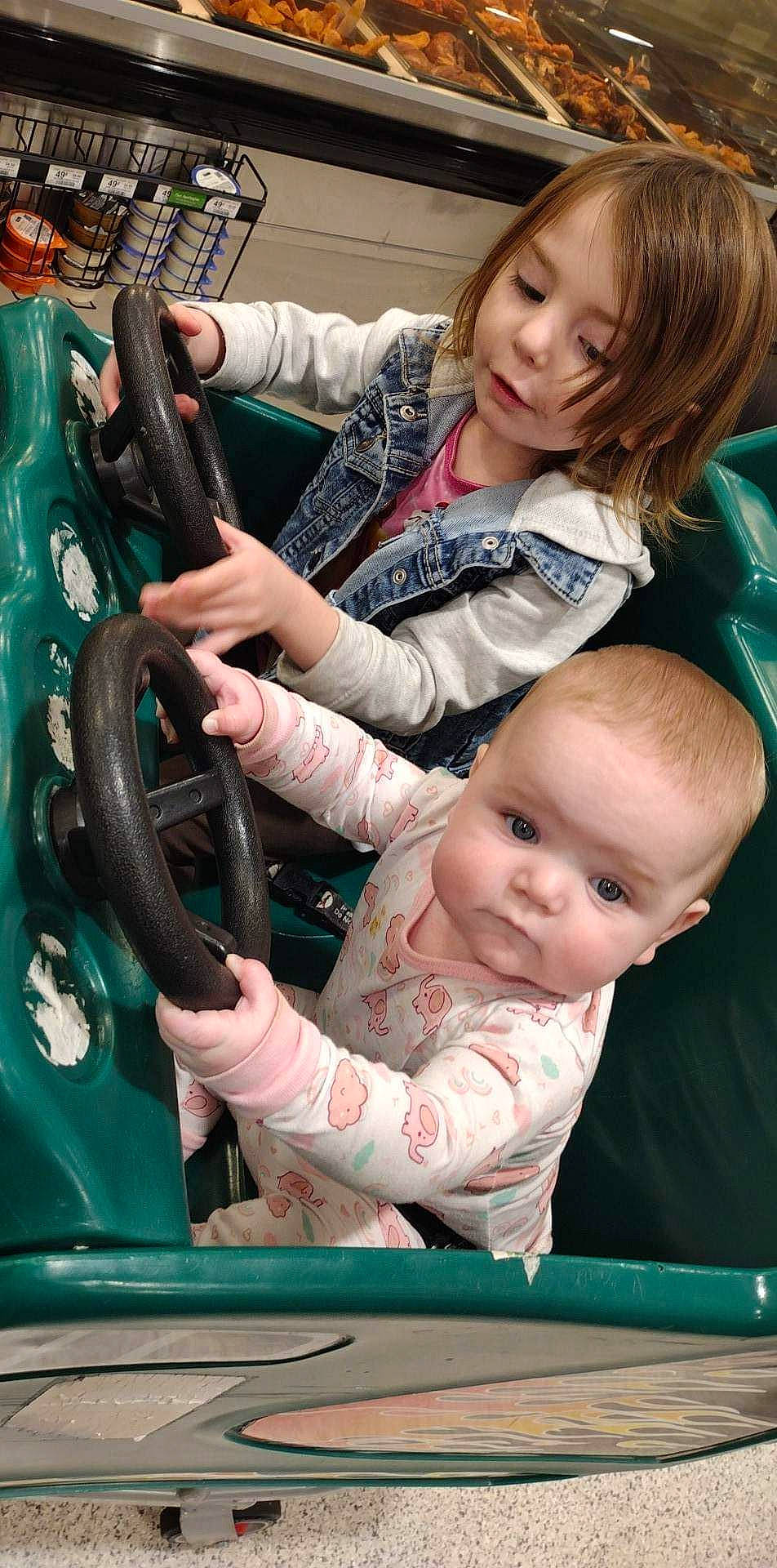 Erica is registered to the contest to win money with this photo: auto_part, automotive_design, baby, baby_carriage, baby_toddler_clothing, cheek, child, event, eye, fun, happy, leisure, motor_vehicle, person, photograph, sitting, skin, snapshot, standing, steering_wheel