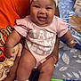 Xamira joined the competition — help win amazing prizes! adult_hand, baby, bow, bracelet, child, cute, happy, headband, indoor, infant, jewelry, orange_shirt, pattern, person, pink_onesie, smartphone, smiling, socks, table, tablecloth