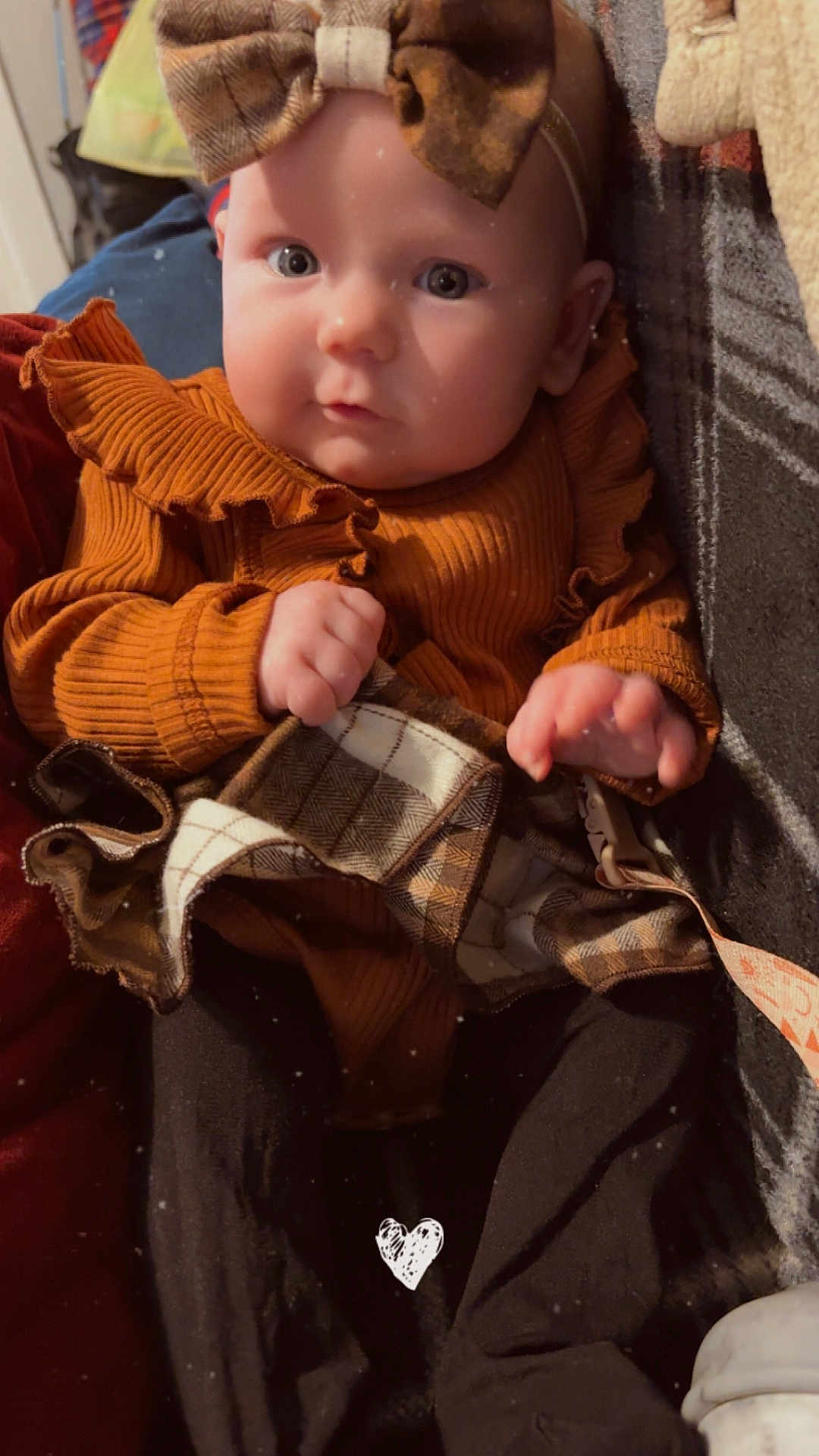 Nora is registered to the contest to win money with this photo: baby, child, infant, ruffled_sweater, plaid_skirt, headband, bow, hands, face, eyes, indoor, cozy, warm_colors, clothing, portrait, cute, sitting, soft_texture, person, closeup