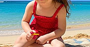 Natalie is registered to the contest to win money with this photo: beach, child, girl, happy, nature, ocean, outdoor, playful, polka_dot, red_dress, sand, sitting, sky, smile, summer, sunny, towel, vacation, water, waves