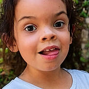 Natalie joined the competition — help win amazing prizes! child, face, portrait, expression, tongue_out, wide_eyes, smile, young, curly_hair, outdoor, nature, greenery, casual_clothing, headshot, happy, cute, person, skin, eyebrows, daylight