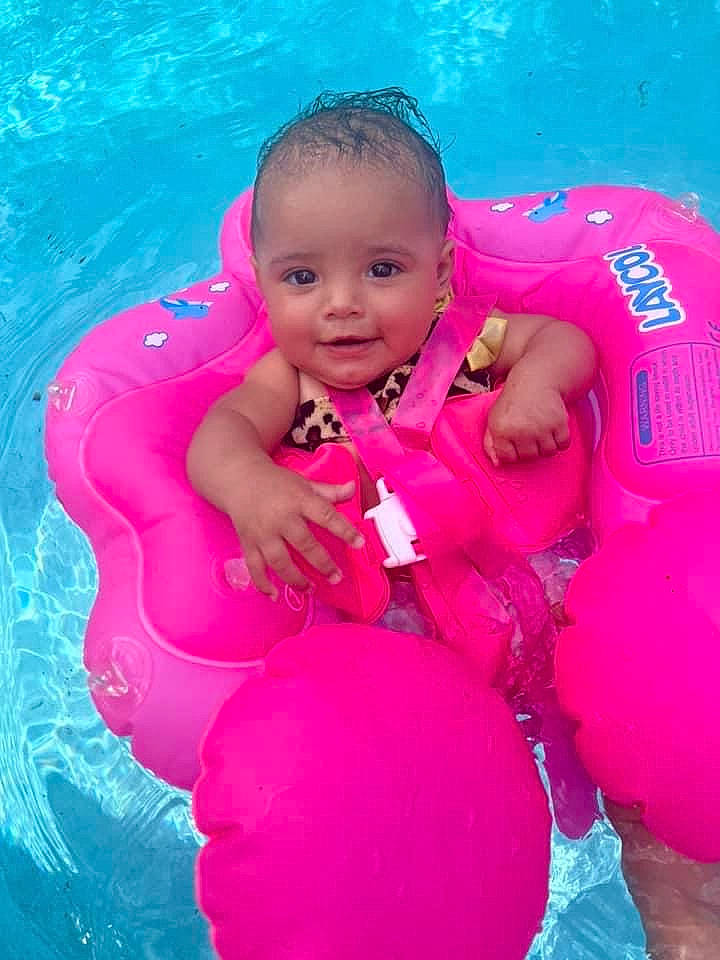Jezalise is registered to the contest to win money with this photo: aqua, baby, baby_float, baby_toddler_clothing, bathing, child, facial_expression, fun, happy, inflatable, joy, leisure, magenta, person, personal_protective_equipment, pink, product, recreation, smile, swimming_pool