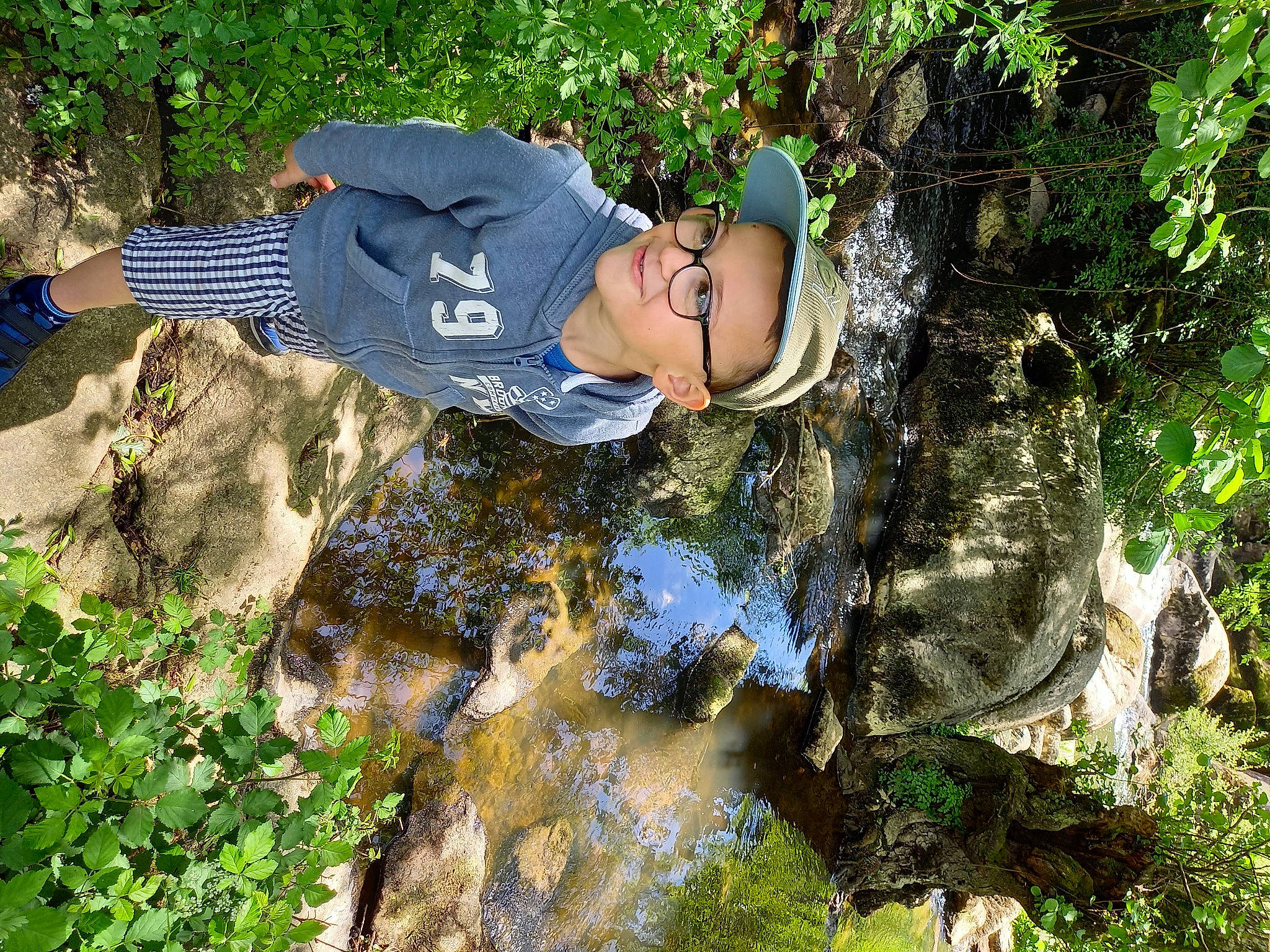 Malone participe au concours pour gagner de l'argent avec cette photo : bedrock, electric_blue, forest, grass, groundcover, hat, headwear, joy, jungle, landscape, leisure, natural_landscape, people_in_nature, person, plant, recreation, rock, shrub, soil, vegetation