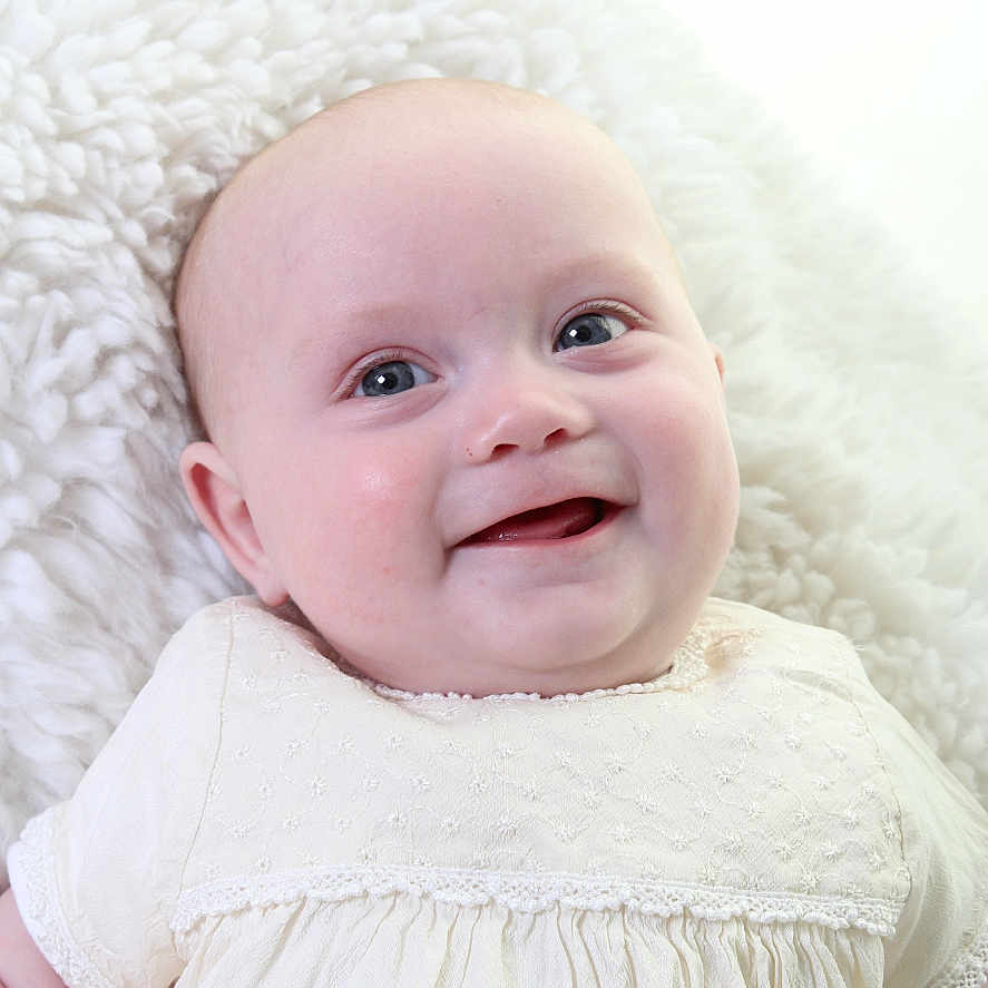 Lua Mary Janet Ellis joined the competition — help win amazing prizes! baby, child, closeup, cute, expression, eyes, face, fluffy_blanket, happy, head, indoors, infant, lying_down, portrait, skin, small_person, smiling, soft_texture, white_dress, young