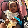 Symphony is registered to the contest to win money with this photo: baby, infant, car_seat, pink, toy, blue, smiling, happy, pigtails, dress, sunlight, outdoor, child, cute, portrait, sitting, hands, feet, clothing, accessories