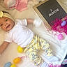 baby, infant, 2_months, smiling, headband, white_shirt, yellow_pants, stuffed_animals, easter_eggs, pink_shredded_paper, blanket, toy, hand, soft_toys, lying_down, cute, indoors, celebration, child, happy
