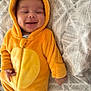 baby, child, infant, smiling, costume, orange, fuzzy, hood, bear, onesie, bed, blanket, pattern, cute, happy, person, sleepwear, indoors, soft, face