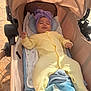 baby, stroller, blanket, headwrap, yellow_onesie, infant, sleeping, cozy, soft, child, outdoor, sunlight, comfort, plush, cute, relaxing, fabric, footed_pajamas, newborn, portrait