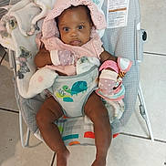 Journey is registered to the contest to win money with this photo: baby, infant, bouncer, blanket, pink_clothing, mittens, toy, floor_tiles, baby_seat, child, cute, indoor, toddler, colorful, animal_print, comfort, portrait, smiling, happy, seated
