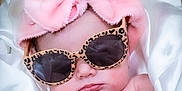 Willow is registered to the contest to win money with this photo: baby, infant, sunglasses, pink_towel, turban, leopard_print, fabric, silk, wrapped, cute, face, hand, relaxing, sleepy, indoor, portrait, child, fashion, accessory, headwear