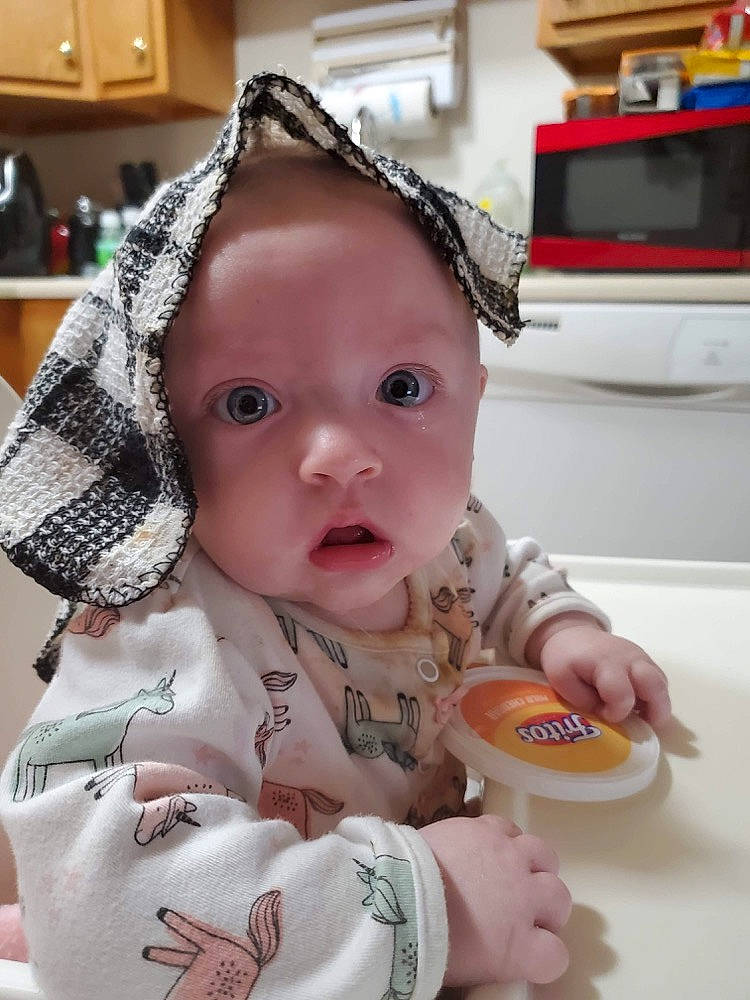 Isabella is registered to the contest to win money with this photo: baby, baby_products, baby_toddler_clothing, chair, cheek, child, comfort_food, dishware, eating, eye, food, head, junk_food, nose, person, plate, room, sitting, sweetness, tableware