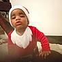 Uriel participe au concours pour gagner de l'argent avec cette photo : baby, child, christmas, clothing, cute, expression, face, festive, hand, headwear, holiday_costume, indoor, person, portrait, red_clothing, santa_hat, skin, toddler, white_beard_design, young_child