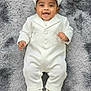 adorable, baby, baby_boy, cap, child, close_up, cute, fashion, formal_wear, happy, indoors, infant, lying_down, one_person, portrait, shoes, smiling, soft_rug, toddler, white_clothing