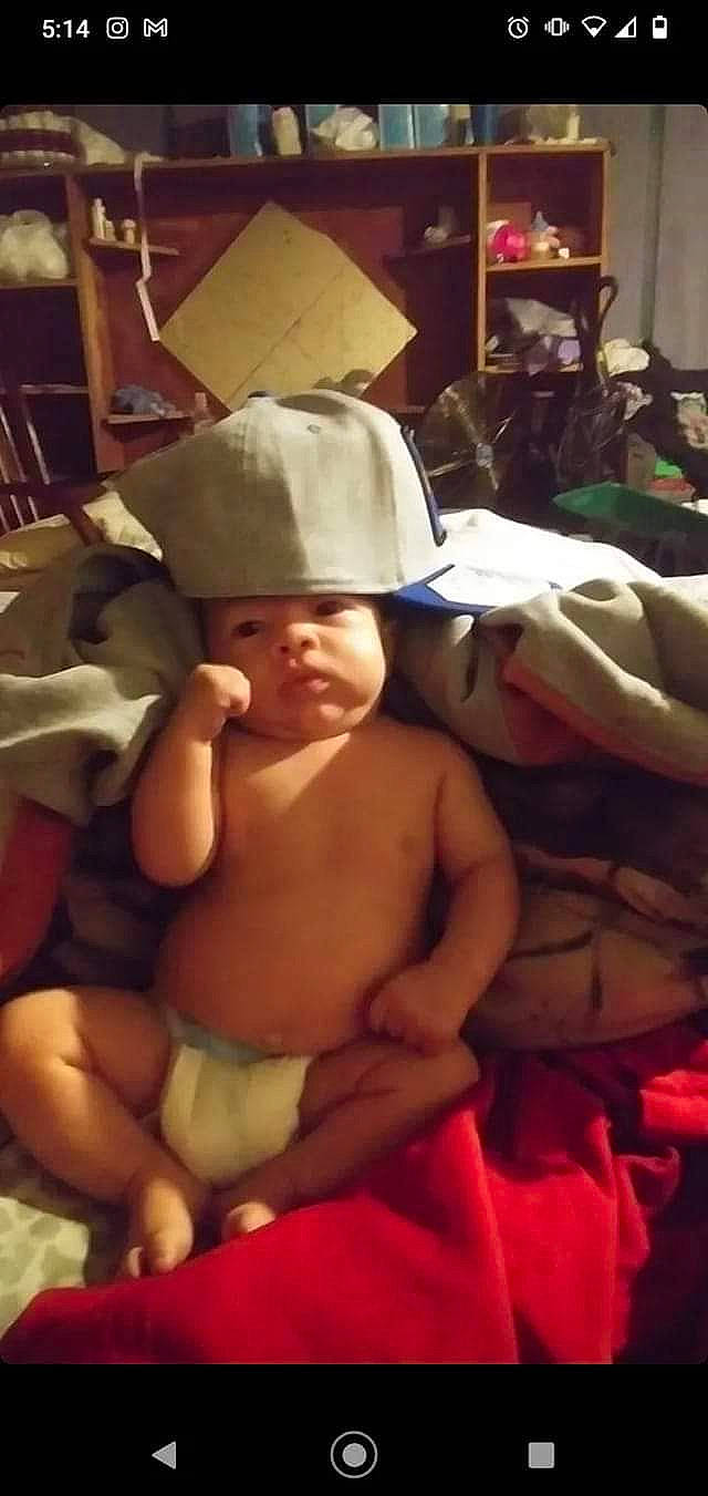 Houston is registered to the contest to win money with this photo: abdomen, baby, baby_products, barechested, cap, cheek, chest, child, comfort, diaper, fun, headwear, helmet, human_body, human_leg, person, room, sitting, thigh, thumb