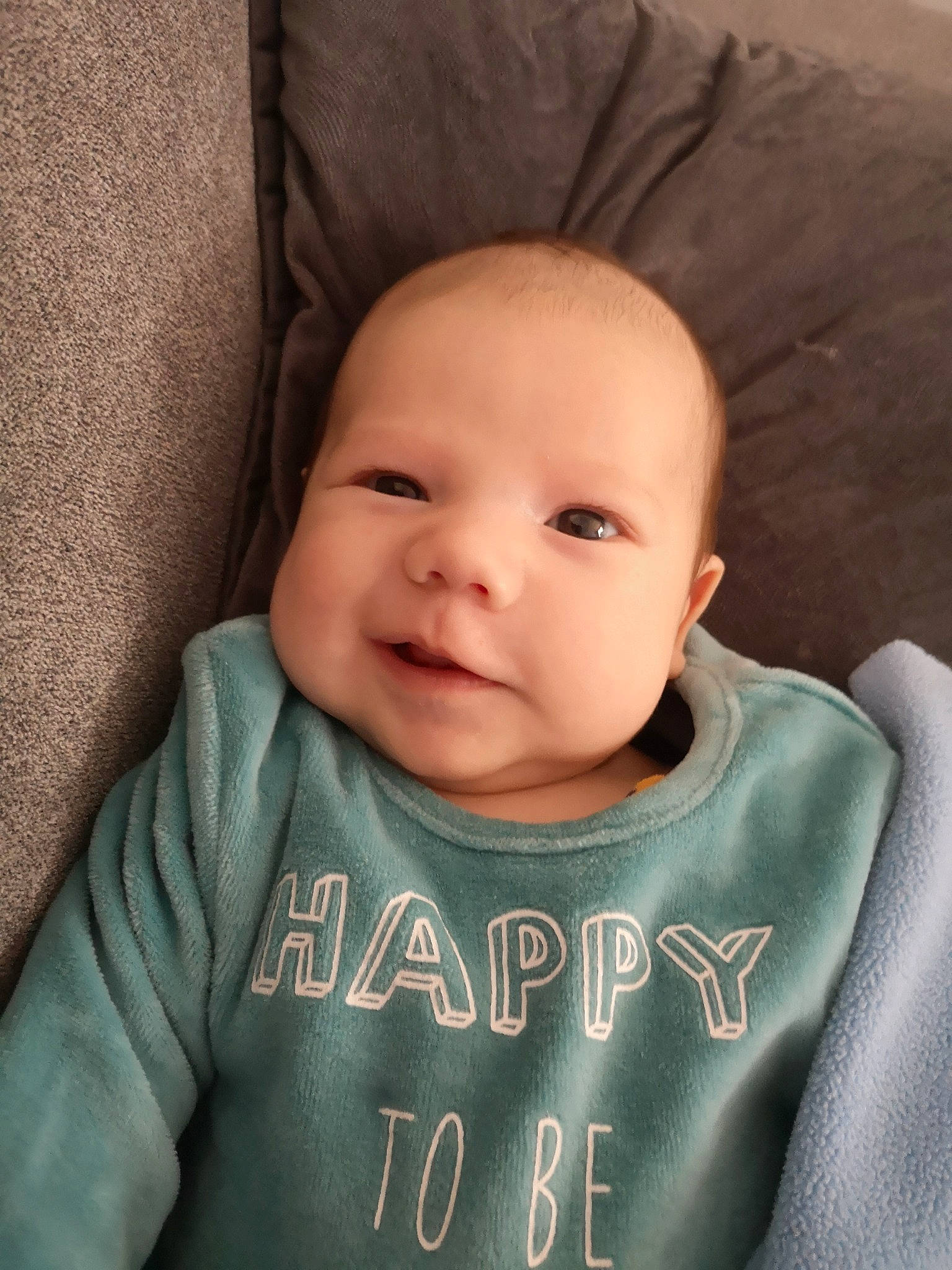 Bryann participe au concours pour gagner de l'argent avec cette photo : baby, baby_toddler_clothing, cheek, comfort, cool, eyebrow, face, forehead, grey, happy, head, iris, neck, nose, outerwear, person, skin, sleeve, smile, textile