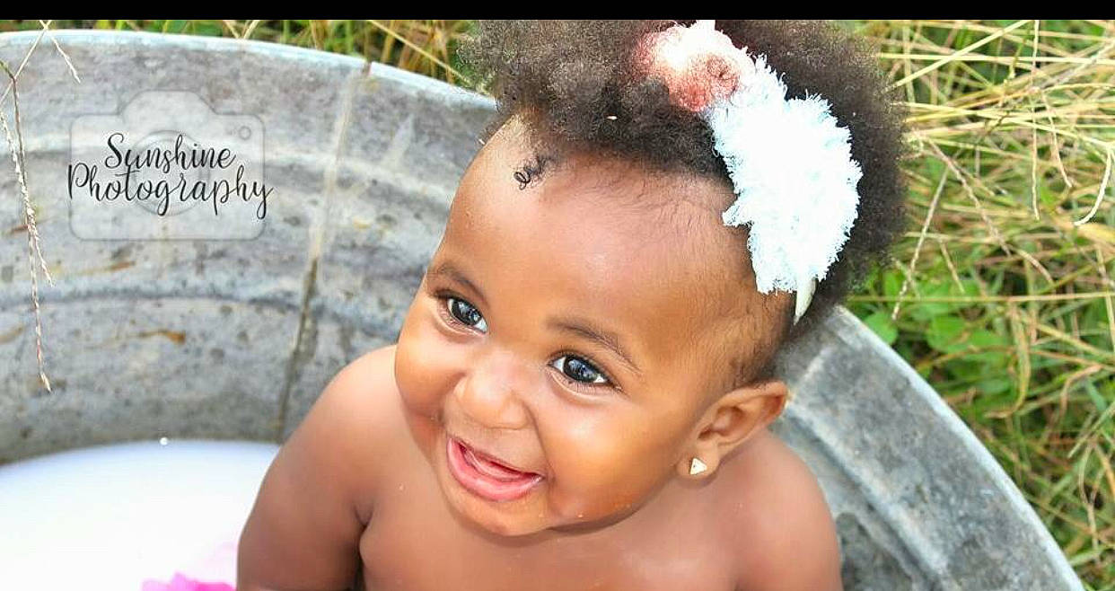 Layla is registered to the contest to win money with this photo: baby, black_hair, cheek, child, ear, eye, face, fashion_accessory, forehead, hair, hair_accessory, hairstyle, head, headband, joy, neck, nose, person, skin, smile