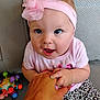 baby, child, hand, pink_headband, flower, leopard_print, pants, toy, couch, holding_hands, smiling, cute, infant, person, sitting, indoor, clothing, face, happy, bright_eyes
