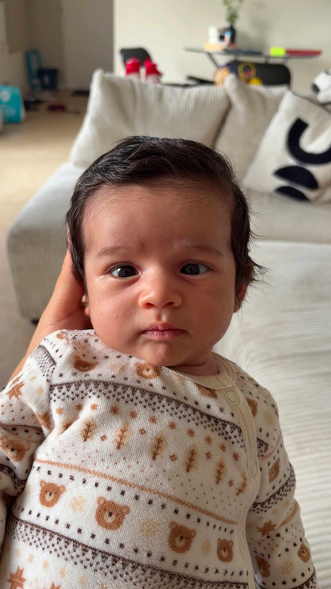 Nael a rejoint le concours — aidez-le/la à gagner de superbes lots ! baby, bear_pattern, child, closeup, couch, cozy, curious, cute, expression, face, hand, indoor, infant, living_room, patterned_clothing, person, portrait, soft_lighting, sweater, young_child