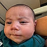 Yetzael is registered to the contest to win money with this photo: baby, infant, child, portrait, close_up, face, eyes, nose, mouth, cheeks, serious_expression, indoor, clothing, teal_shirt, sitting, reclining, couch, blanket, head, photography