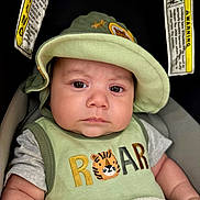 Yetzael joined the competition — help win amazing prizes! baby, infant, child, portrait, car_seat, sun_hat, green_clothing, tiger, roar, serious_expression, face, eyes, indoor, close_up, seated, blanket, automobile, safety_warning, textile, photography