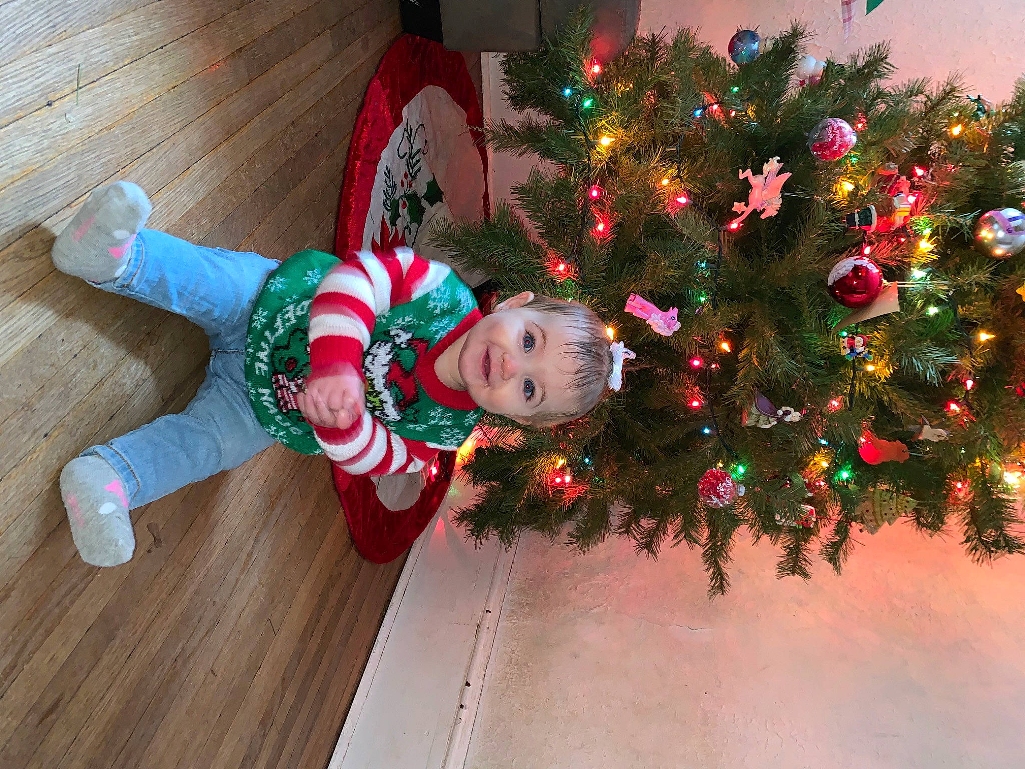 Harper joined the competition — help win amazing prizes! christmas, christmas_decoration, christmas_ornament, christmas_tree, conifer, event, evergreen, flooring, happy, hardwood, holiday, holiday_ornament, joy, ornament, person, plant, smile, sock, toddler, tradition