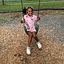 child, girl, swing, playground, smiling, happy, outdoor, grass, chain_link_fence, pink_clothing, beads, hair, shoes, socks, wood_chips, summer, daylight, casual, leisure, fun
