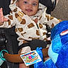 Phoenix is registered to the contest to win money with this photo: baby, child, stroller, plush_toy, blue_dinosaur, hoodie, bear_pattern, smiling, happy, cute, infant, toy, sitting, white_shoes, indoor, person, playful, closeup, casual_clothing, joyful