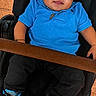 baby, child, smiling, blue_shirt, black_pants, sneakers, stroller, face, portrait, cute, happy, jewelry, earrings, footwear, infant, seated, casual_clothing, indoor, person, young_child