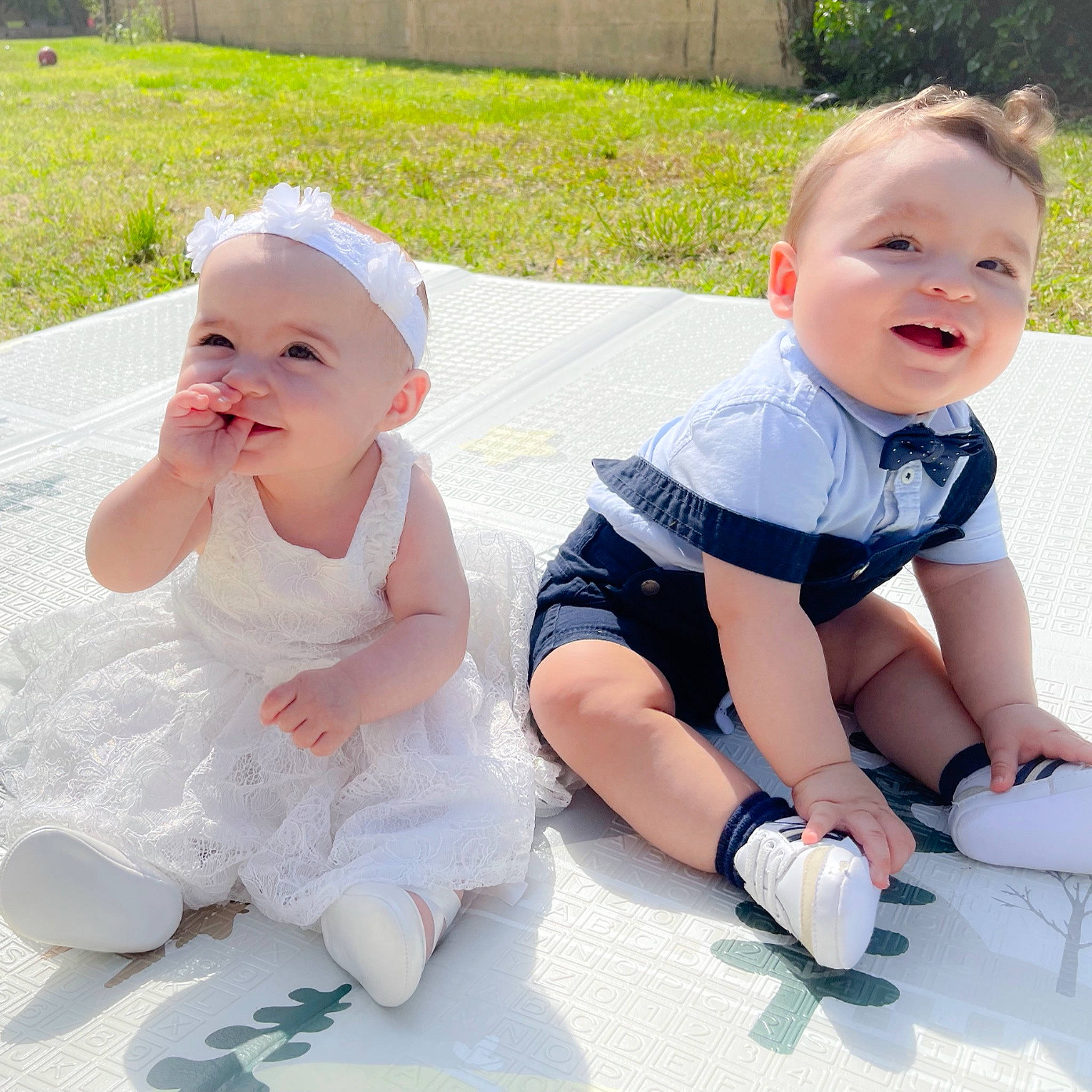 Tali participe au concours pour gagner de l'argent avec cette photo : baby, baby_toddler_clothing, child, dress, finger, fun, gesture, grass, happy, leg, leisure, person, photograph, pink, plant, product, sitting, skin, smile, summer