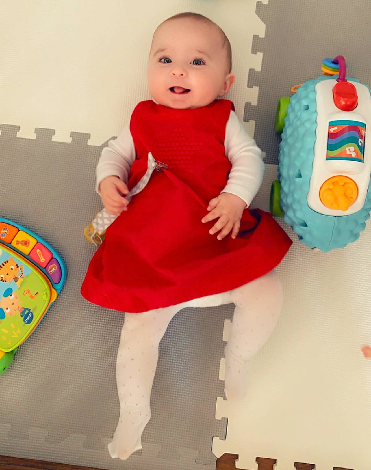 Tali a rejoint le concours — aidez-le/la à gagner de superbes lots ! baby, baby_products, baby_toddler_clothing, child, dress, happy, human_leg, knee, magenta, pattern, person, pink, play, sitting, sleeve, smile, t_shirt, textile, thigh, toddler