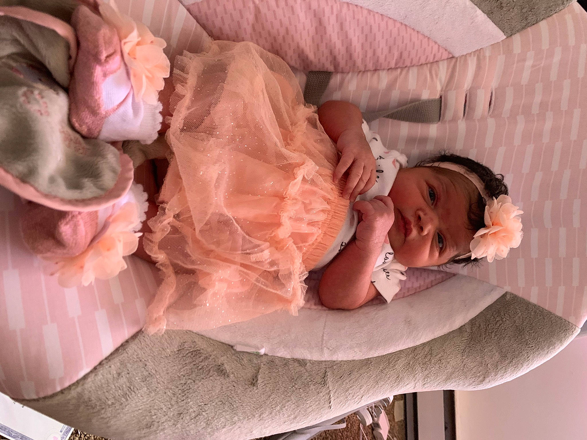 Mylah is registered to the contest to win money with this photo: baby, bridal_accessory, child, comfort, dress, embellishment, eyelash, fashion_accessory, hair_accessory, happy, headgear, headpiece, headwear, peach, person, pink, rose_order, sitting, skin, sweetness