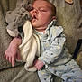 baby, sleeping, stuffed_toy, bunny, blanket, pacifier, blue_onesie, soft_toy, infant, child, cozy, cute, comfort, resting, peaceful, furniture, indoors, portrait, hand, footwear