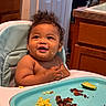 Layla joined the competition — help win amazing prizes! baby, high_chair, food, smiling, curly_hair, kitchen, happy, infant, meal, cooking, wooden_cabinet, door, plate, scrambled_eggs, bacon, cucumber, messy, child, person, cute