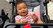 Layla joined the competition — help win amazing prizes! baby, stroller, watermelon, smiling, child, outdoor, dog, pink_clothing, seat, tray, happy, person, food, animal, leash, pavement, grass, hand, face, cute
