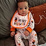 Kyaire joined the competition — help win amazing prizes! baby, child, infant, onesie, bib, halloween, pumpkin, ghost, couch, pillow, quilted, orange, white, sitting, cute, indoor, portrait, clothing, face, person