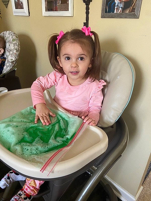 Avyahna is registered to the contest to win money with this photo: baby_toddler_clothing, chair, child, dress, fashion_accessory, fun, happy, magenta, person, picture_frame, pink, plate, play, room, sitting, skin, sleeve, t_shirt, table, tableware