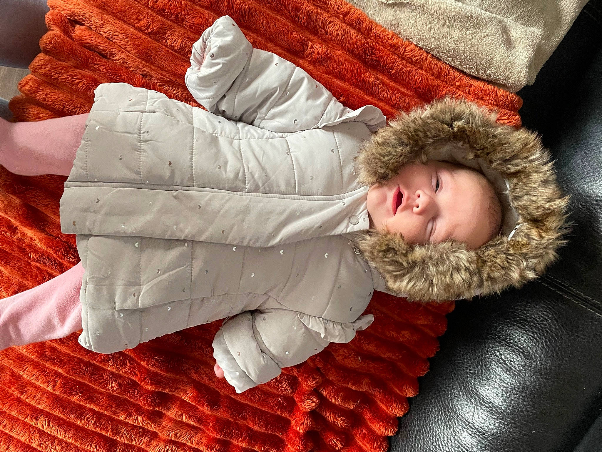 Julia participe au concours pour gagner de l'argent avec cette photo : baby, carmine, child, comfort, couch, flooring, fur, fur_clothing, gesture, linens, outerwear, person, room, sitting, sleeve, smile, textile, throw_pillow, toddler, wood