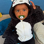 Oweynn participe au concours pour gagner de l'argent avec cette photo : toddler, child, pacifier, onesie, hood, black_and_white, costume, bed, blue_background, beige_blanket, indoor, cute, sitting, face, hand, eyes, clothing, soft, plush, portrait