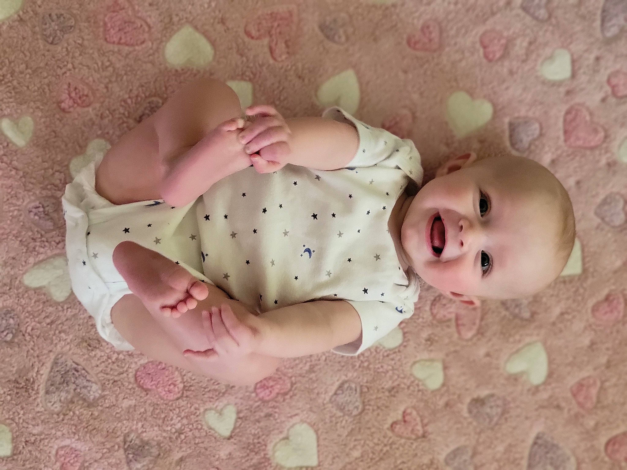 Hannah is registered to the contest to win money with this photo: arm, baby, baby_products, baby_safety, baby_toddler_clothing, bed, cheek, child, comfort, eye, face, grass, head, human_body, linens, person, pink, skin, sleeve, textile