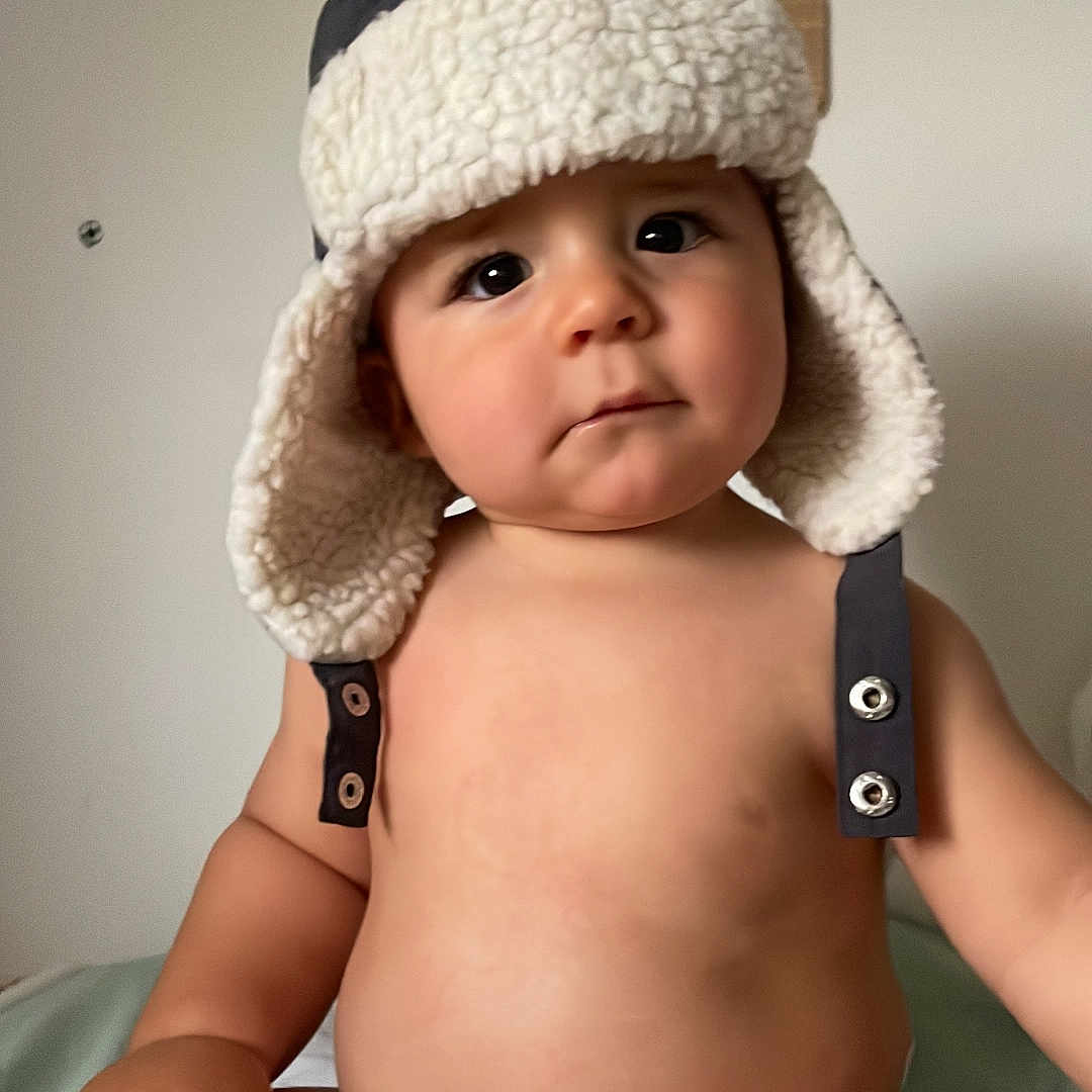 Ayden participe au concours pour gagner de l'argent avec cette photo : baby, beanie, bodypart, bonnet, cap, clothing, diaper, face, finger, hand, hat, head, hood, newborn, person, photography, portrait, sitting, sunhat