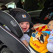 Malakai joined the competition — help win amazing prizes! baby, car_seat, beanie, blanket, toy, smiling, child, car_interior, blue_eyes, happy, clothing, seatbelt, infant, cute, warm, hats, portrait, indoors, young_child, cozy